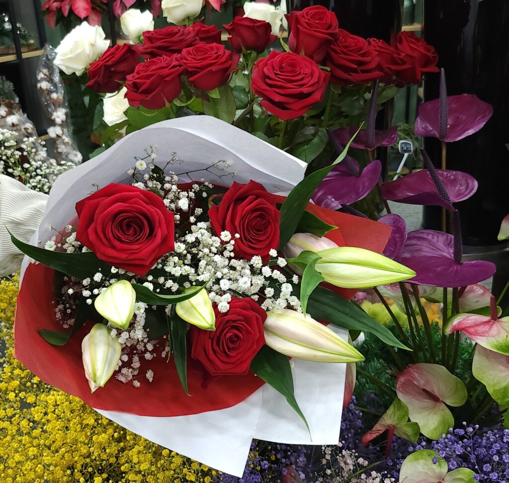 imaqe bouquet de roses rouges gypsophiles branchages vert noué a la a main Une Belle Composition